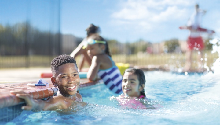 Three kids in an outdoor pool