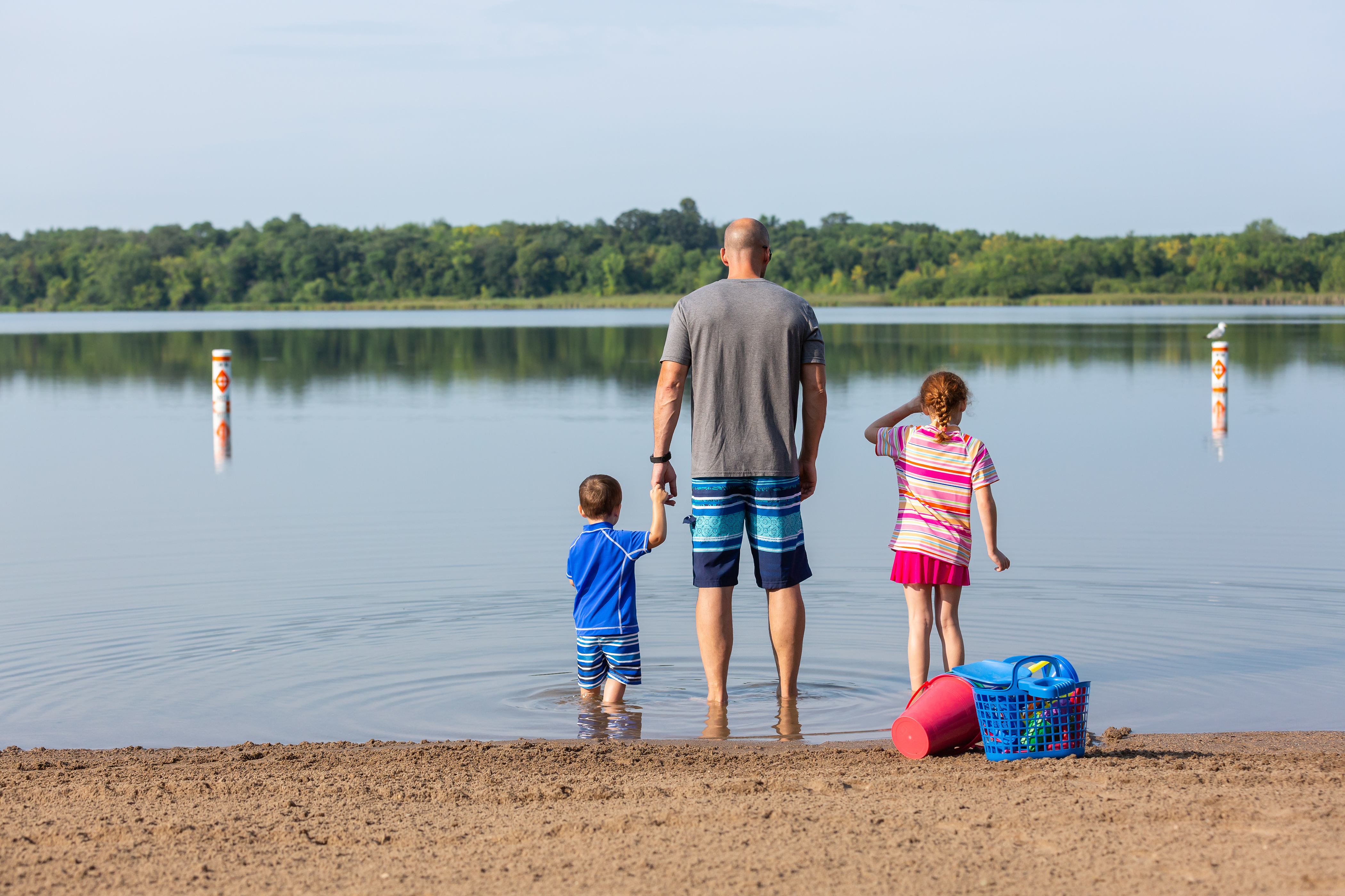 Family standing at lake edge